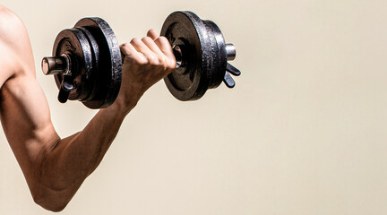 Skinny guy hold dumbbells up in hands. Thin man in sports with dumbbells. Weak man lift a weight, dumbbells, biceps, muscle, fitness. Man holding dumbbell in hand