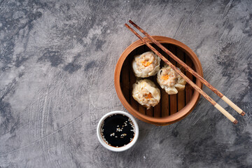 Chinese steamed dumplings or  Dim Sum in bamboo steamer on dark abstract background