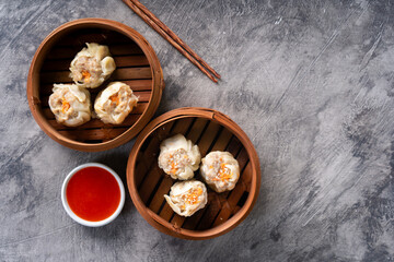 Chinese steamed dumplings or  Dim Sum in bamboo steamer on dark abstract background