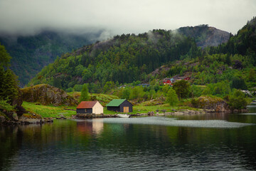 Low clouds over houses in the fjord close to Bergen in Norway