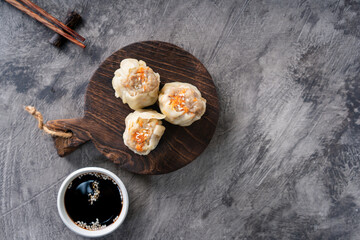 Chinese steamed dumplings or  Dim Sum in bamboo steamer on dark abstract background