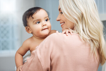Bonding, love and mother holding her baby in the nursery room of their modern family home. Happiness, smile and young woman hugging a cute girl infant child with care and affection in their house.
