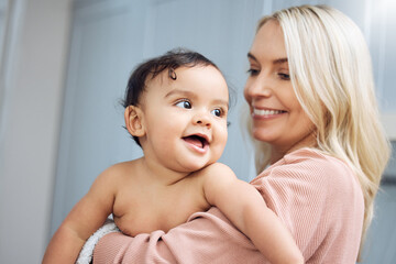 Love, smile and mother holding with her baby in the nursery room of their modern family home. Happy, bonding and young woman hugging her cute girl infant child with care and affection in their house.