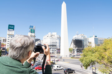 Photographer taking photo at 9 de Julio Avenue and Obelisk in Buenos Aires, Argentina