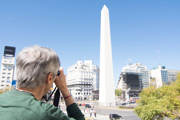 Photographer taking photo at 9 de Julio Avenue and Obelisk in Buenos Aires, Argentina