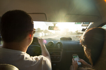 Couple driving at car while using phone gps