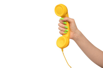 Yellow handset in woman hand with green nails isolated on a white background.