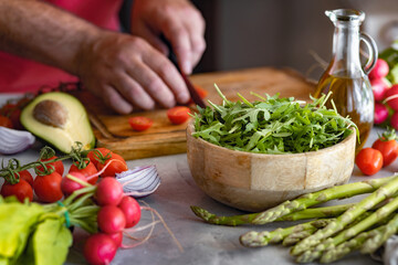 Man cooking healthy vegetarian food while standing at home in the kitchen