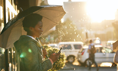 Umbrella, phone and black woman in a city, rain and connection with mobile app, network and...