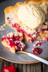 Tart with sour cherry creme, creme patisserie and crumbs, served with vanilla ice cream. Rustic and moody atmosphere and decoration. 