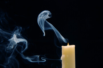 Smoke from an extinguished candle on a dark background. The concept of spirituality and the end of...