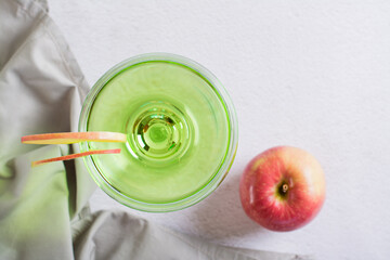 close up of homemade green apple martini cocktail with apple pieces in glasses top view
