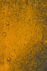 yellow ground turmeric sprinkled on a black slate board