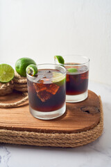 Glass of tasty Cuba Libre cocktail on table from caribbean, focus selective