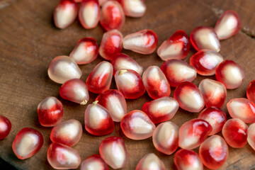 Red pomegranate seeds on the table and the board