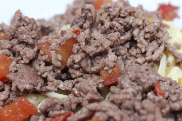 close up of minced meat. spaghetti with ground beef. meal with selective focus. ground beef with tomato and spaghetti.