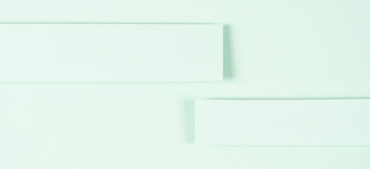 Light green paper background. Blank paper strips on light green background with shadows. Two horizontal sheet of paper for notice, message, copy space for text