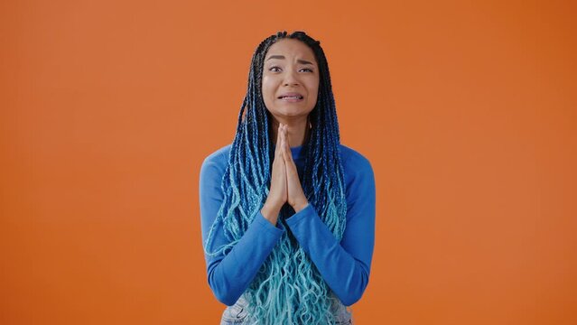 Woman makes wish showing prayer gesture and crosses fingers