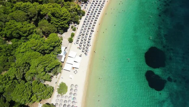 Skiathos beach with many beach umbrellas, aerial view