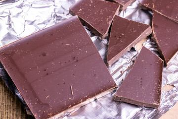 A broken chocolate bar in a paper and foil package