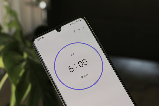 A phone with a black and white 5-minute timer to study with the pomodoro method on a blurry background