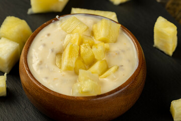 milk pineapple yogurt with pieces of pineapple and other fruits
