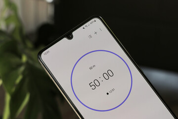 A phone with a black and white 50-minute timer to study with the pomodoro method on a blurry background
