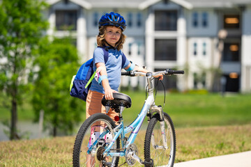 Little kid boy ride a bike in the park. Kid cycling on bicycle. Happy smiling child in helmet riding a bike. Boy start to ride a bicycle. Sporty kid bike riding on bikeway. Kids bike.