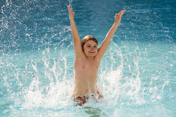 Kid splashing water in pool. Little kid splashing in blue water of swimming pool. Cute child swimming and splashing water with drops in pool. Child splashing and having fun in swim poolside.