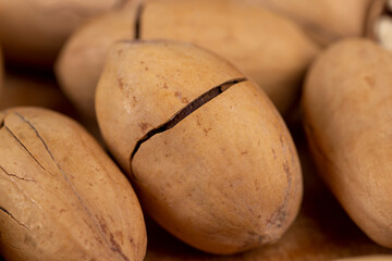 cracked unpeeled pecans close-up on the table