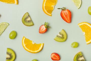 Citrus fruits and strawberries, pattern flat lay, top view. Summer layout on colored background
