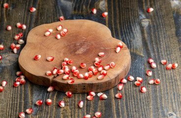 Red pomegranate seeds on the table and the board