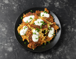 Cabbage pancake with greek yogurt on black plate