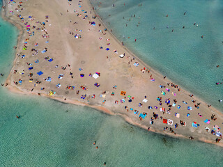 Aerial drone view of sandy beach at Elafonissi, Greek island Crete with colorful umbrellas and turquoise water