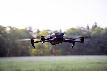 Rehkitzrettung - Drohne mit Wärmekamera fliegt am frühen Morgen die Wiese ab.