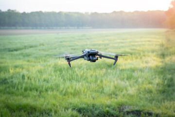 Drohne mit Wärmekamera fliegt über eine Wiese, um Rehkitze zu erkennen.