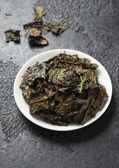 Fototapeta na wymiar A delicious Kale chips, snack on white plate. Healthy vegetable food.