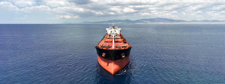 Aerial drone ultra wide panoramic photo with copy space of huge industrial bulk carrier tanker anchored in deep blue Aegean sea