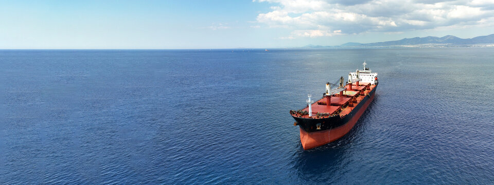 Aerial drone ultra wide panoramic photo with copy space of huge industrial bulk carrier tanker anchored in deep blue Aegean sea