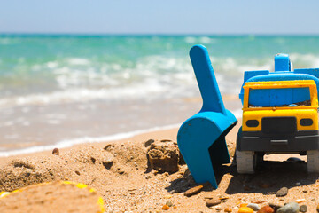 Fototapeta na wymiar Juguetes de niño sobre la arena en la orilla de la playa