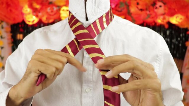 Knotting tie. Halloween costume. dark party Decor. Man. White shirt with dots. Medium closeup.