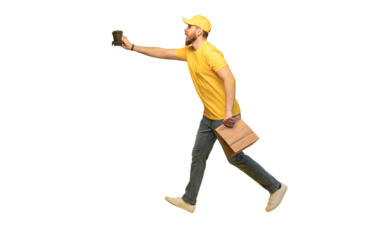 Portrait of young delivery man in yellow uniform with paper packet and takeaway coffee isolated over transparent background