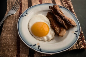 fried egg with bacon on the table