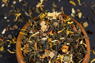 A large amount of dry green tea with pieces of fruit