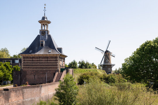 Old city wall and city gate - Dalempoort, with the corn mill 'De Hoop' in the background in the city of Gorinchem.