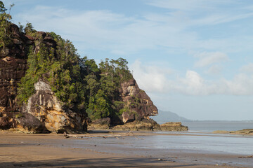 Cliff in Bako national park, sunny day, blue sky and sea. Vacation, travel, tropics concept