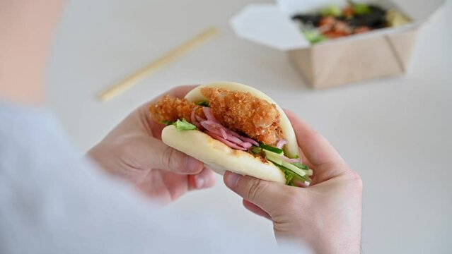  man eating bao bun. Traditional asian street food concept