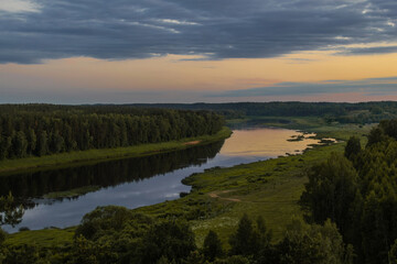 Landscape view on the bend of Daugava river in Naujene parish, Daugavpils district, Latgale region, Latvia, which is a part of Nature Park “Daugavas Loki” at summer after sunset - obrazy, fototapety, plakaty