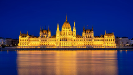 Fototapeta na wymiar Parliament building in Budapest, Hungary. Parliament and reflections in the Danube River. Blue hour and evening illumination of the building. High resolution photo.