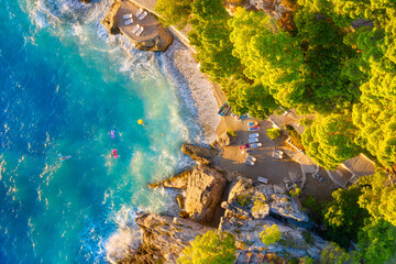 View from the air on the beach. Aerial view. Rest on the beach. Sea relaxation and travel. The forest near the sea. Azure water on the sea. A bright sunny day during a summer vacation.